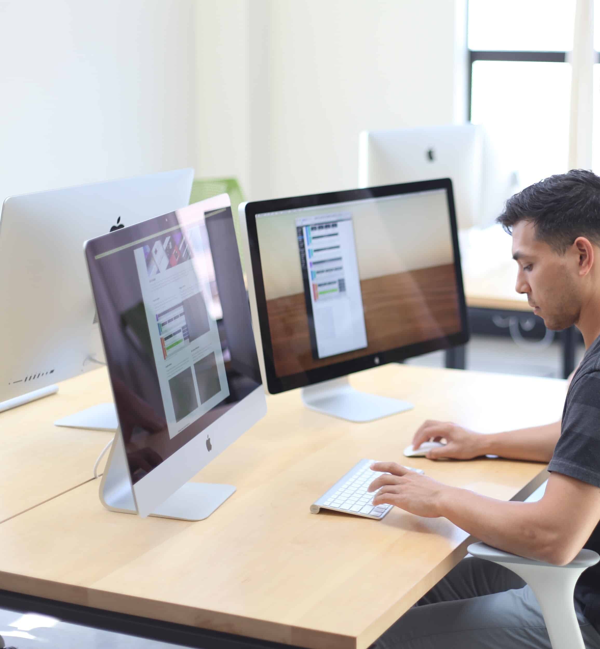 Développeur travaillant sur deux écrans dans un espace lumineux